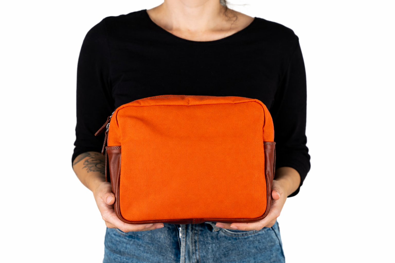 Modelo sosteniendo neceser de cuero y tela rojo