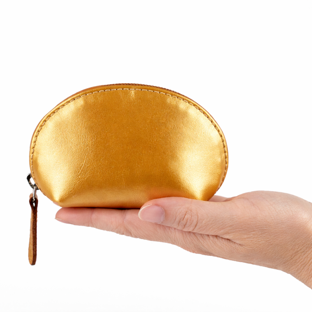Mano con monedero de cuero dorado